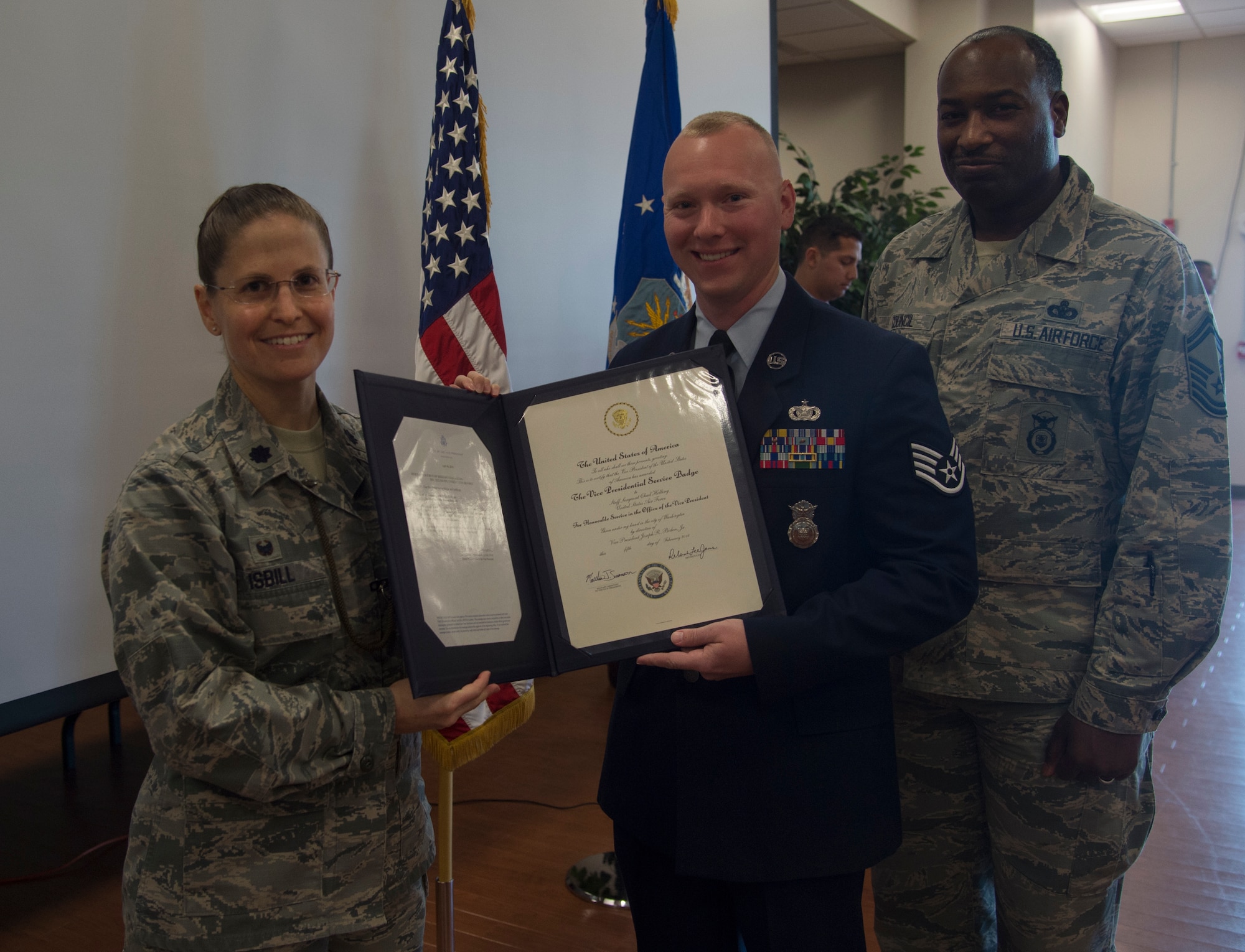 Lt. Col. Sarah Isbill, the 811th Security Forces Squadron commander, poses for a picture with Staff Sgt. Chad Holling, 811th SFS vice presidential security team leader, and Senior Master Sgt. Dana Council, 811th SFS manager, during the Vice Presidential Service Badge awards ceremony at Joint Base Andrews, Md., April 15, 2016. The VPSB is awarded to military members who serve as a full-time uniformed service aide to the VP of the United States of America. (U.S. Air Force photo by Senior Airman Mariah Haddenham/Released)