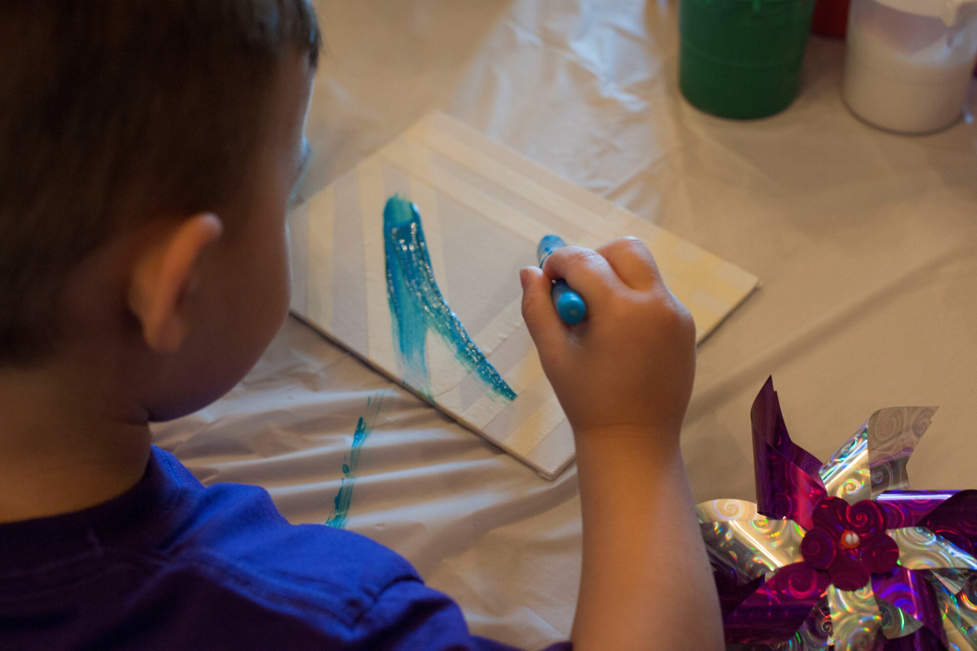 David, a Family Child Care member, paints a canvas during a craft fair for Month of the Military Child at Liberty Park Housing Office April 16, 2015. The craft fair was coordinated by Joint Base Andrews Family Child Care for MOTMC, a time to honor military youth for the important role they play contributing to the strength of the military family. (U.S. Air Force photo by Airman 1st Class Rustie Kramer/Released)