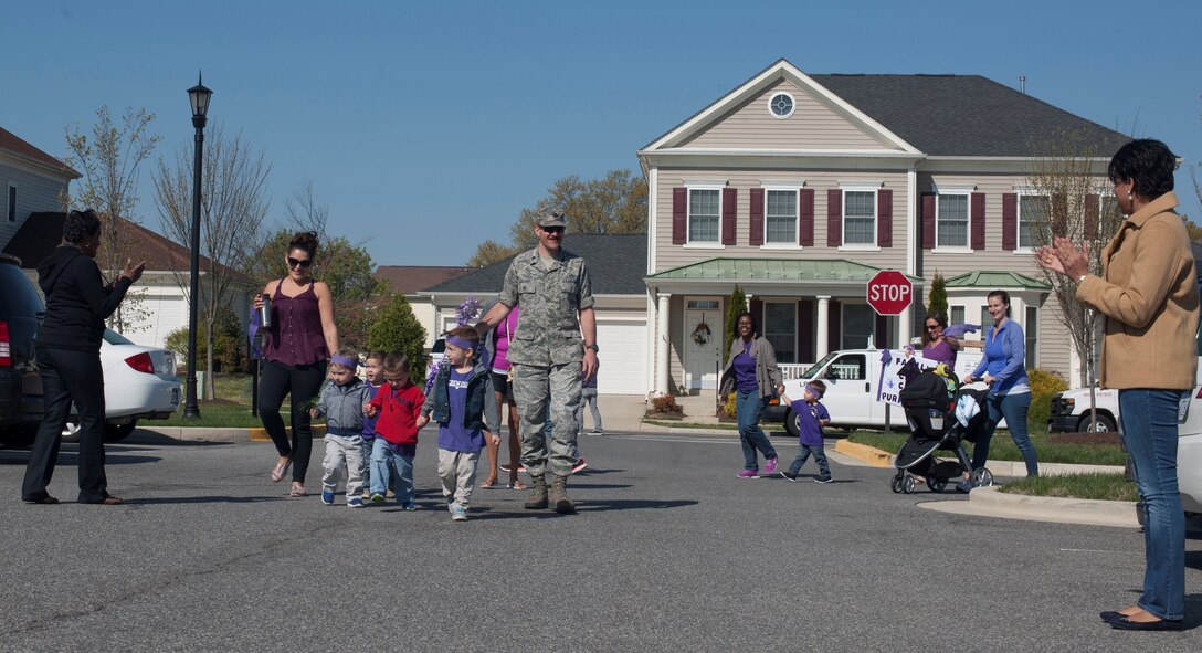 Members of Joint Base Andrews Family Child Care march in a purple parade to celebrate National Purple Up day at Liberty Park Housing Office, April 15, 2016. Purple Up day is part Month of the Military Child, a time to honor military youth for the important role they play contributing to the strength of the military family. (U.S. Air Force photo by Airman 1st Class Rustie Kramer/Released)