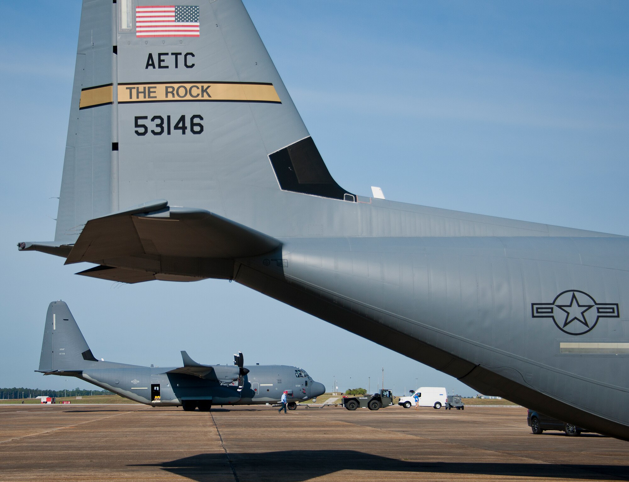 A modified MC-130J is pulled to its parking spot beside another C-130 by an aircraft tow vehicle at Eglin Air Force Base, Fla. The test aircraft was fitted with vertical fins on each wing, called winglets.  The 413th Flight Test Squadron aircrew and engineers tested the modified aircraft over eight flights.  The goal of the tests was to collect data on possible fuel efficiency improvements and performance with the winglets and lift distribution control system installed.  (U.S. Air Force photo/Samuel King Jr.)