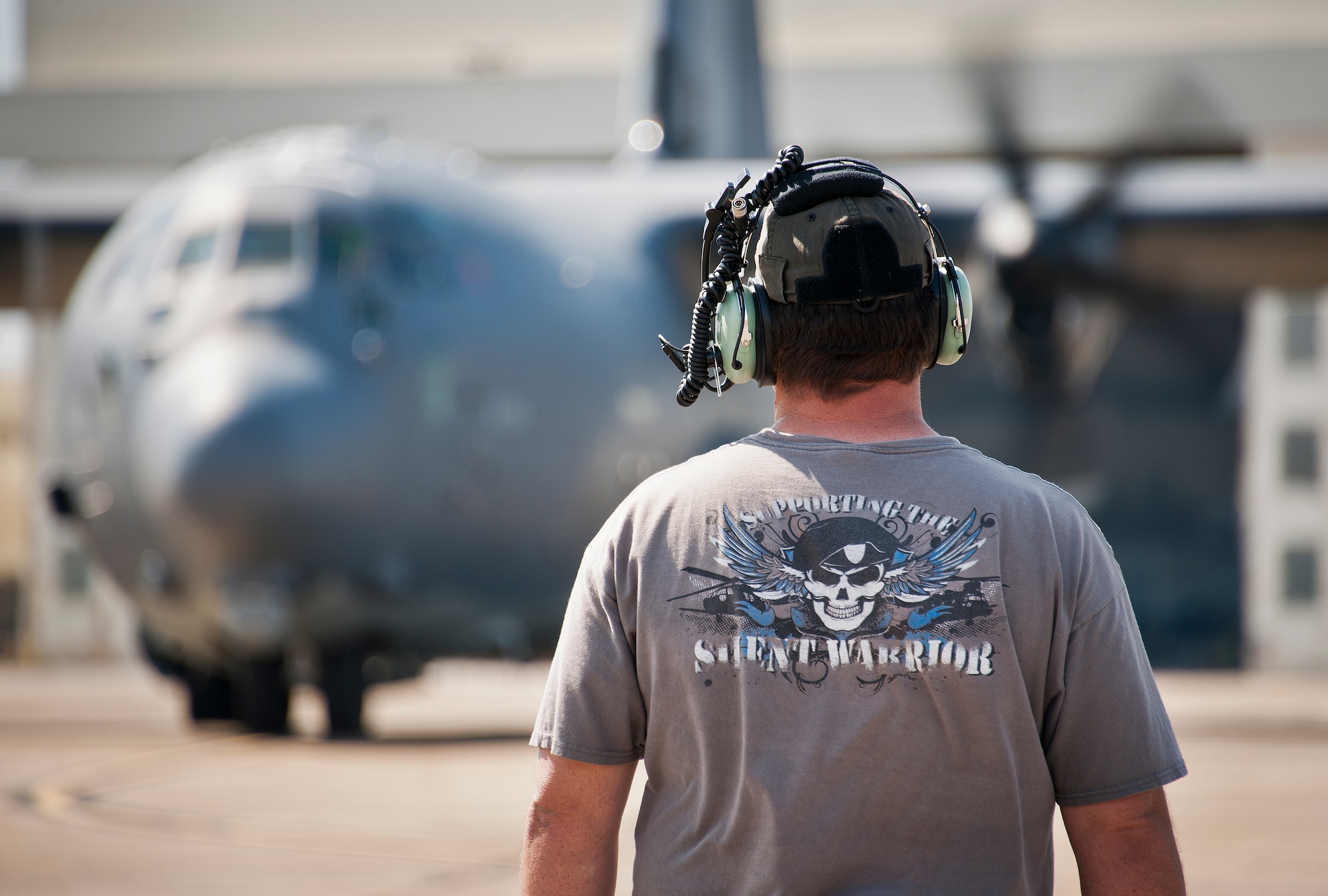 Jeff Frisbe, a Lockheed Martin contractor with the 413th Flight Test Squadron, waits for word to begin marshalling out the MC-130J for a test mission at Eglin Air Force Base, Fla. The aircraft has been fitted with vertical fins on each wing, called winglets.  The 413th Flight Test Squadron aircrew and engineers tested the modified aircraft over eight flights.  The goal of the tests was to collect data on possible fuel efficiency improvements and performance with the winglets and lift distribution control system installed.  (U.S. Air Force photo/Samuel King Jr.)