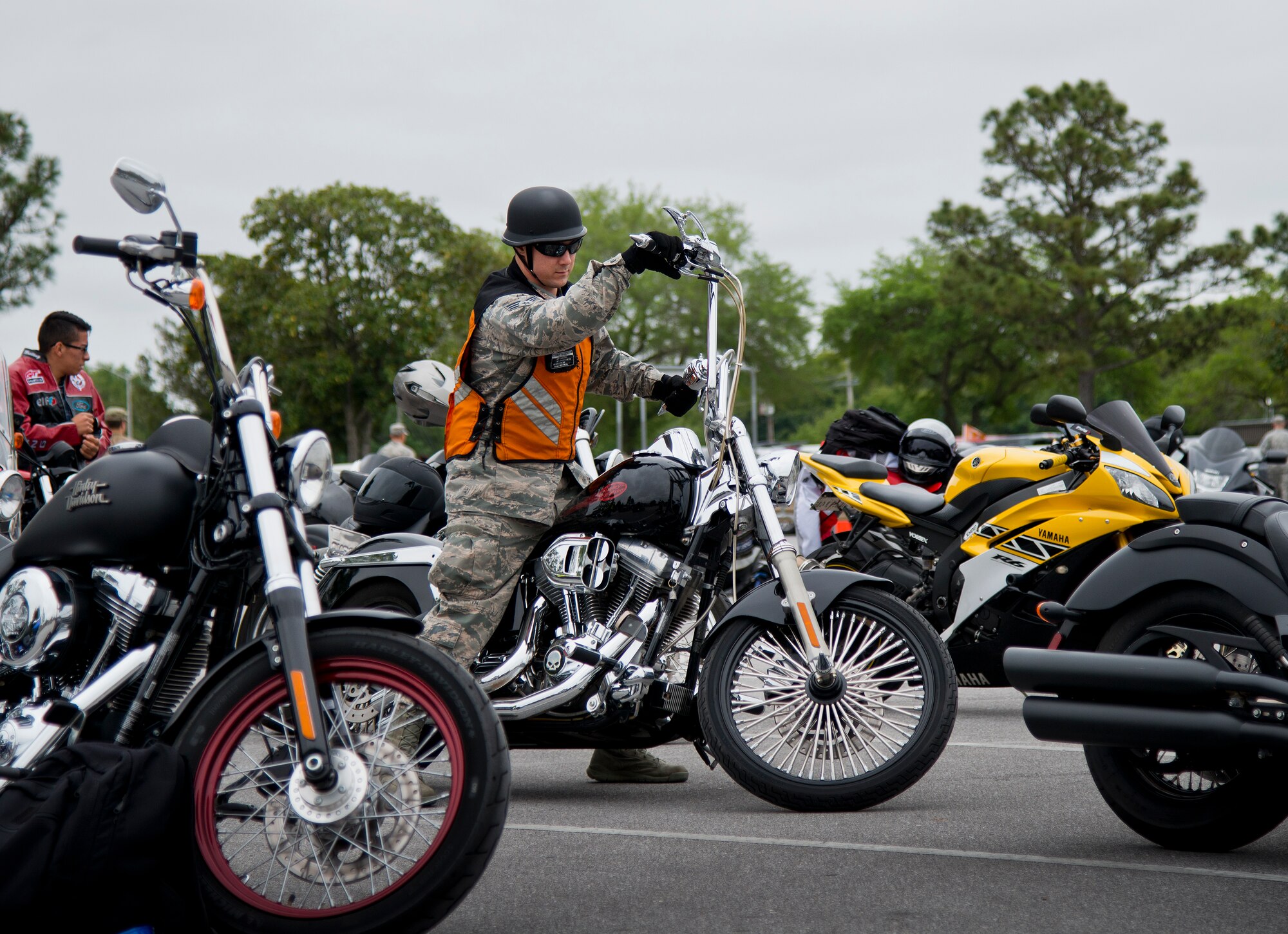 An Airman maneuvers his bike before heading out after the base’s annual motorcycle safety rally April 15 at Eglin Air Force Base, Fla.  More than 500 civilian and military riders rode in for the joint 53rd Wing/96th Test Wing event. (U.S. Air Force photo/Samuel King Jr.)
