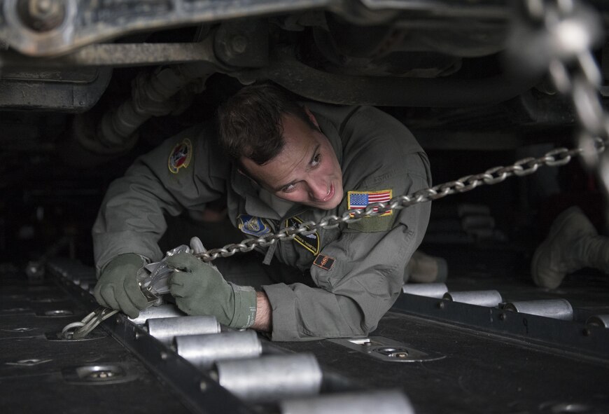 Staff Sgt. Andrew Thompson, 36th Airlift Squadron loadmaster, uses a chain to strap down a Japan Ground Self-Defense Force vehicle to a C-130 Hercules at Chitose, Hokkaido, Japan, April 18, 2016. The 374th Airlift Wing assisted the Government of Japan by airlifting vehicles and personnel from Hokkaido to the island of Kyushu in response of the recent earthquakes. (U.S. Air Force photo by Staff Sgt. Michael Washburn/Released)