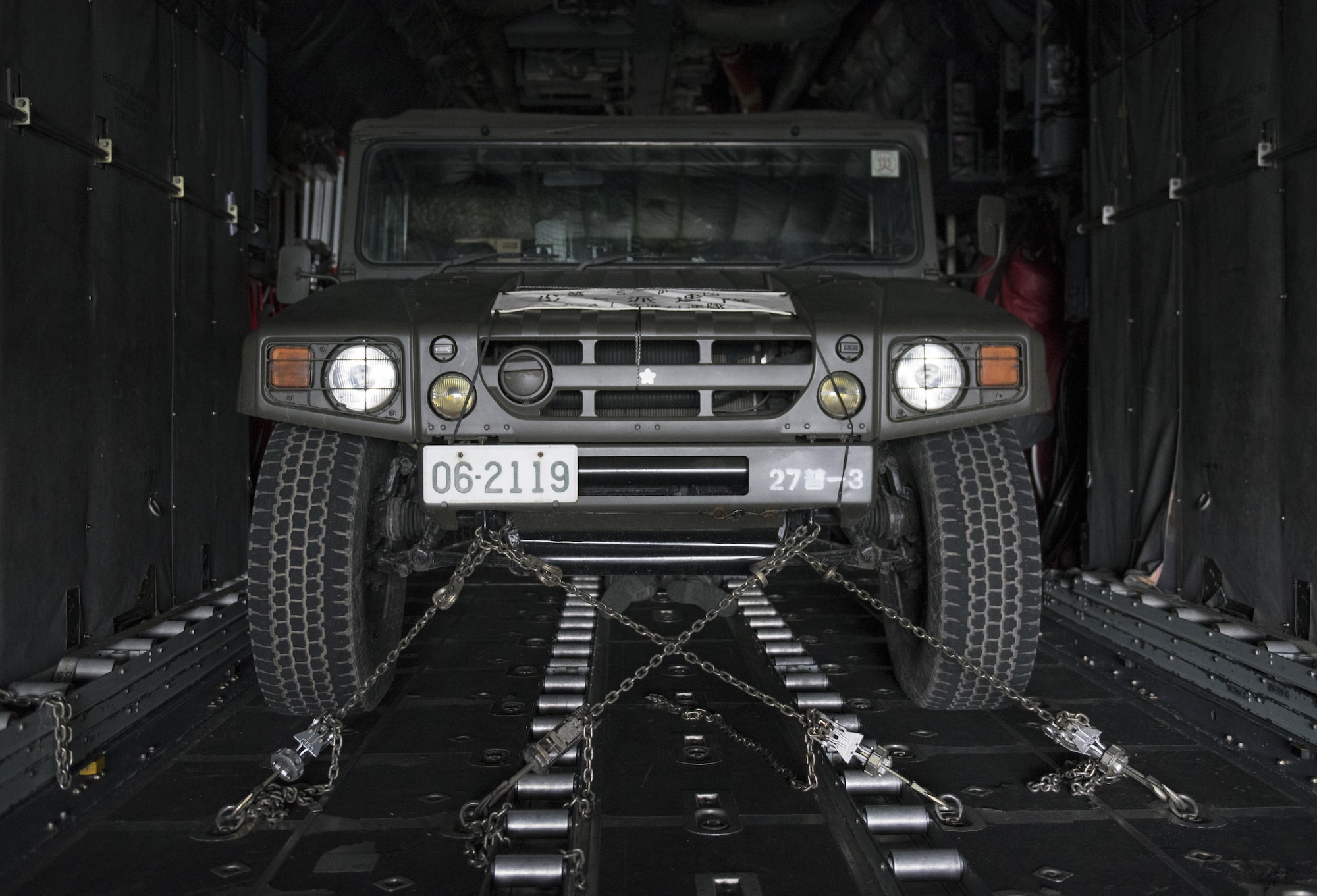 A Japan Ground Self-Defense Force vehicle sits strapped down in a U.S. Air Force C-130 Hercules at Chitose, Hokkaido, Japan, April 18, 2016. Two C-130s from Yokota Air Base, Japan picked up four vehicles and eight JGSDF members and flew them to the island of Kyushu to assist in disaster relief operations following a series of earthquakes that struck Japan. (U.S. Air Force photo by Staff Sgt. Michael Washburn/Released)