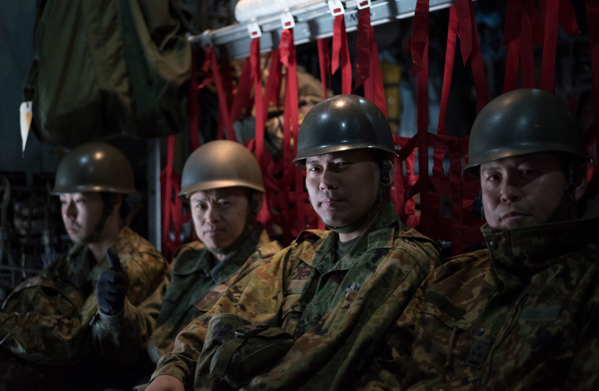 Four Japan Ground Self-Defense Force members sit in a U.S. Air Force C-130 Hercules at Chitose, Hokkaido, Japan, April 18, 2016. The JGSDF members are from Hokkaido but are being flown to Kumamoto Prefecture to assist in the disaster relief effort after a series of earthquakes. (U.S. Air Force photo by Staff Sgt. Michael Washburn/Released)