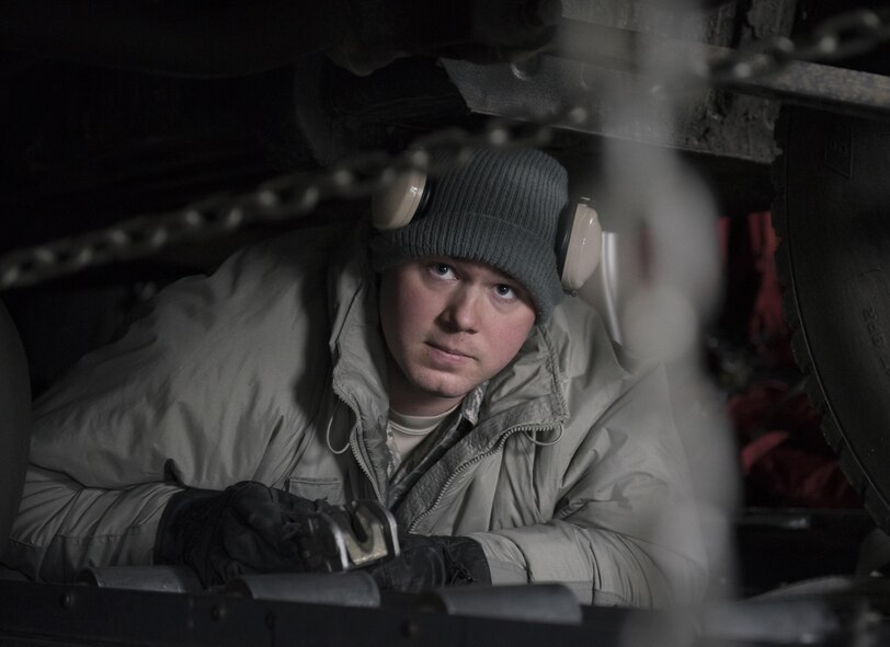 Senior Airman Brandon Ihnat, 374th Logistics Readiness Squadron air transportation specialist, checks two chains that secure a Japan Ground Self-Defense Force vehicle to a C-130 Hercules at Chitose, Hokkaido, Japan, April 18, 2016. The vehicles were being transported from Hokkaido to the island of Kyushu to assist in disaster relief efforts. (U.S. Air Force photo by Staff Sgt. Michael Washburn/Released)