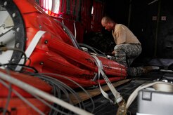 U.S. Army Staff Sgt. King David, 1st Battalion, 228th Aviation Regiment CH-47 Chinook Crew Chief, secures a “Bambi Bucket” in a CH-47 helicopter in preparation for Joint Task Force-Bravo personnel to assist with firefighting efforts in Panama April 15, 2016 at Soto Cano Air Base, Honduras. The Bambi Bucket holds up to 2000 gallons of water and allows fire suppression in areas inaccessible by land. (U.S. Army Photo by Martin Chahin/Released)