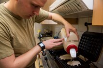 An Airman assigned to the 606th Air Control Squadron prepares for waffles for the deploying service members in a 606th ACS kitchen at Spangdahlem Air Base, Germany, April 6, 2016. The 606th ACS is slated to move to Aviano Air Base, Italy, after their deployed members return. (U.S. Air Force photo by Airman 1st Class Timothy Kim/Released)