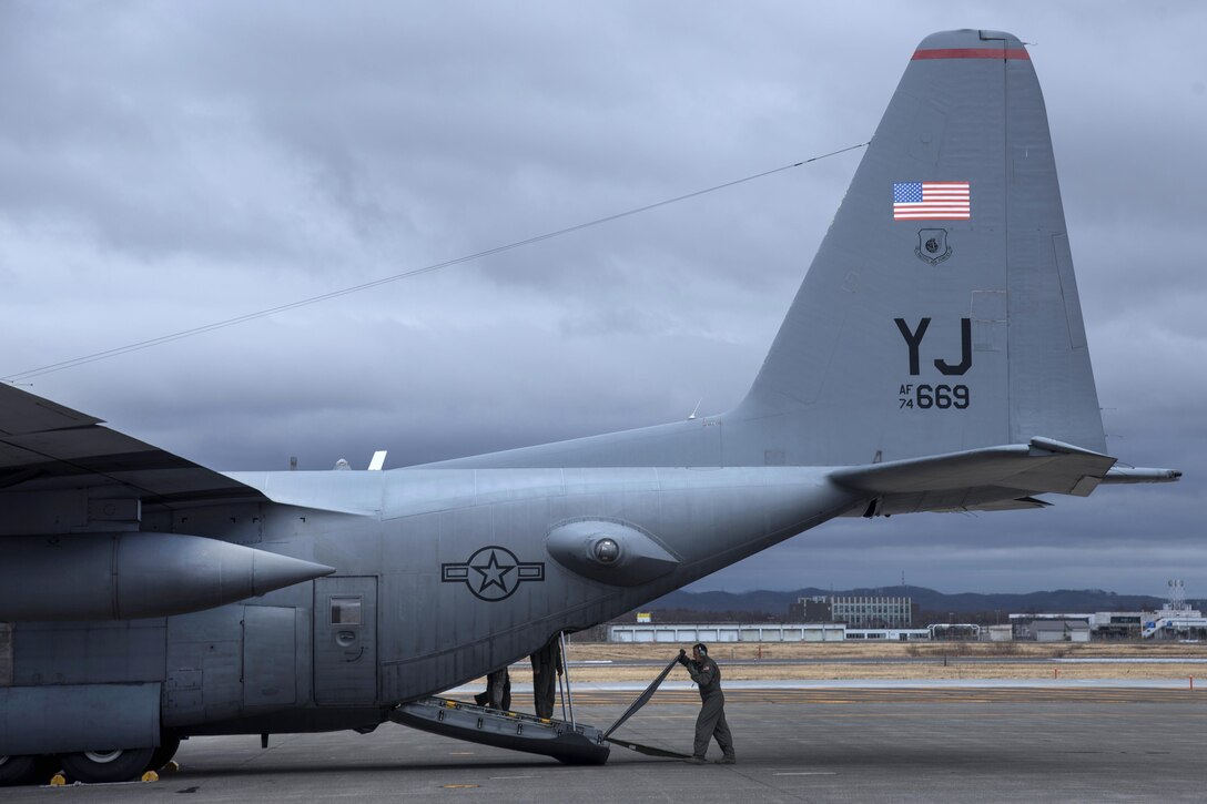 An airman lowers a ramp on the back of a C-130 Hercules aircraft in Chitose, Japan, April 18, 2016. Air Force photo by Staff Sgt. Michael Washburn