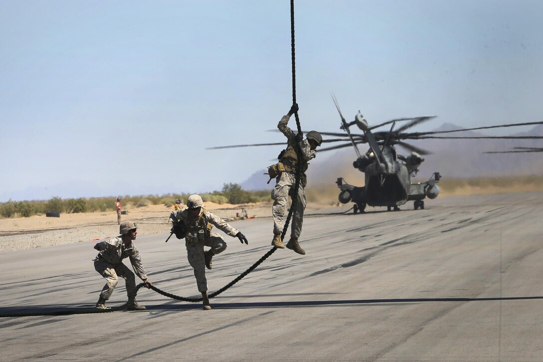 A Marine jumps over a rope during a fast-rope exercise from a CH-53E Super Stallion helicopter in Yuma, Ariz., April 1, 2016. Marine Corps photo by Staff Sgt. Artur Shvartsberg