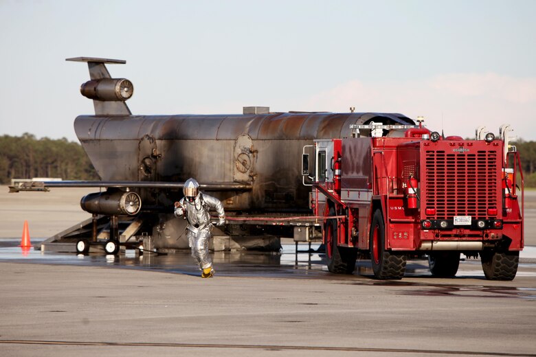 A firefighter runs with a hose to aid in a simulated emergency during a Mass Casualty Exercise on Marine Corps Air Station Cherry Point, N.C., April 7, 2016.  The exercise was designed to simulate the response if an emergency were to occur. Annually, the air station is required to have exercises to ensure protocol and safety standards are met for potential emergencies. On years the biannual air show occurs, the training revolves around scenarios specific to that kind of event. (U.S. Marine Corps photo by Cpl. Jason Jimenez/Released)