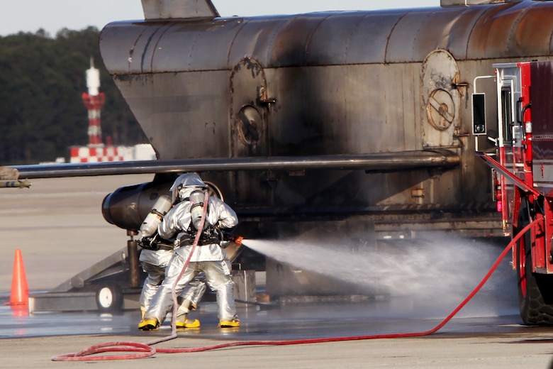 Firefighters practice extinguishing a fire around a staged downed aircraft during a Mass Casualty Exercise on Marine Corps Air Station Cherry Point, N.C., April 7, 2016.  The exercise was designed to simulate the response if an emergency were to occur. Annually, the air station is required to have exercises to ensure protocol and safety standards are met for potential emergencies. On years the biannual air show occurs, the training revolves around scenarios specific to that kind of event. (U.S. Marine Corps photo by Cpl. Jason Jimenez/Released)