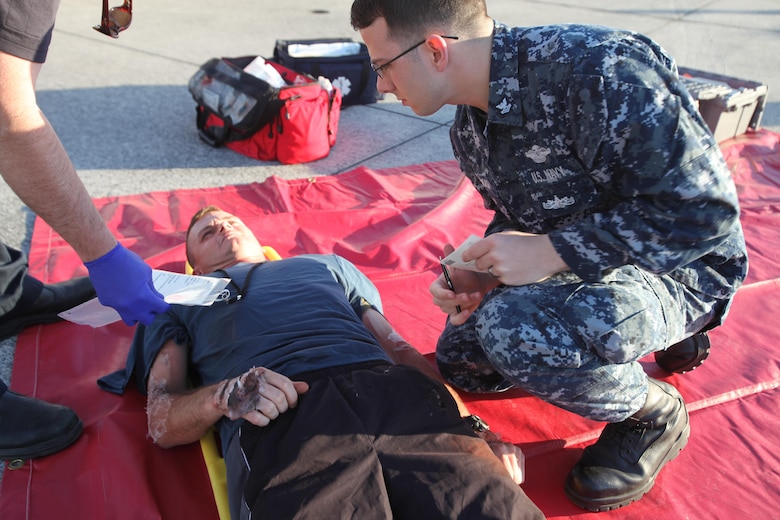 A Navy corpsman tends to a simulated casualty during a Mass Casualty Exercise on Marine Corps Air Station Cherry Point, N.C., April 7, 2016.  The exercise was designed to simulate the response if an emergency were to occur. Annually, the air station is required to have exercises to ensure protocol and safety standards are met for potential emergencies. On years the biannual air show occurs, the training revolves around scenarios specific to that kind of event. (U.S. Marine Corps photo by Cpl. Jason Jimenez/Released)