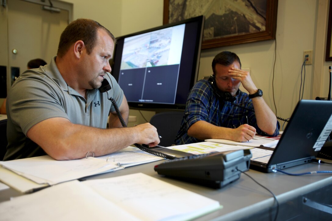 Mike Owens and Grant DeHaven respond to callers during a Mass Casualty Exercise on Marine Corps Air Station Cherry Point, N.C., April 7, 2016.  The exercise was designed to simulate the response if an emergency were to occur. Annually, the air station is required to have exercises to ensure protocol and safety standards are met for potential emergencies. On years the biannual air show occurs, the training revolves around scenarios specific to that kind of event. (U.S. Marine Corps photo by Cpl. Jason Jimenez/Released)