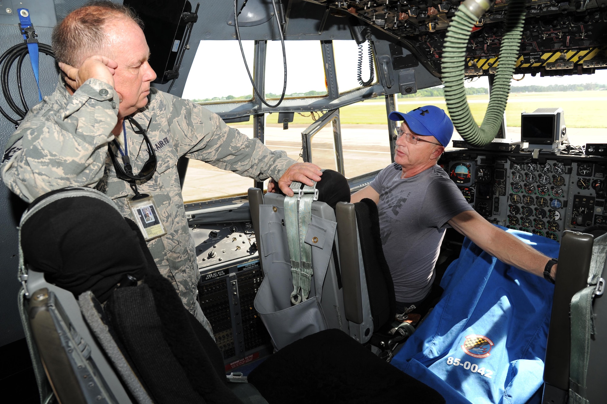 Mark Herndon, former drummer for the band Alabama, talks to Master Sgt. Tom Duke, crew chief, 908th Air Maintenance Squadron, during a flightline tour of a C-130 Hercules from the 908th Airlift Wing, Maxwell Air Force Base, Ala. Hendron, who flies commercial jets out of Birmingham, Ala., talks to Duke about the C-130's flight capabilities while sitting in the pilot's seat in the aircraft's cockpit.