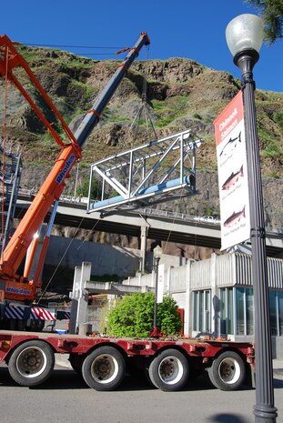 Contractors use large cranes to hoist heavy loads over the top of Lower Granite Lock and Dam’s visitor center and adult fish ladder as they construct a new juvenile fish bypass system leading from the dam to the Juvenile Fish Facility. The fishway improvements are an important part of the Corps’ mission to save salmon and other endangered or threatened species. 