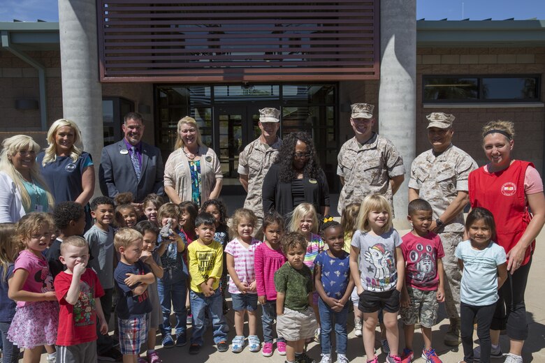 Personnel involved with creating the Child Development Center stand with children during the grand opening and ribbon-cutting ceremony for the CDC aboard the Combat Center April 13, 2016. The development center, also known as ‘Stepping Stones’, is a 37,000-square-foot facility. (Official Marine Corps photo by Cpl. Connor Hancock/Released)