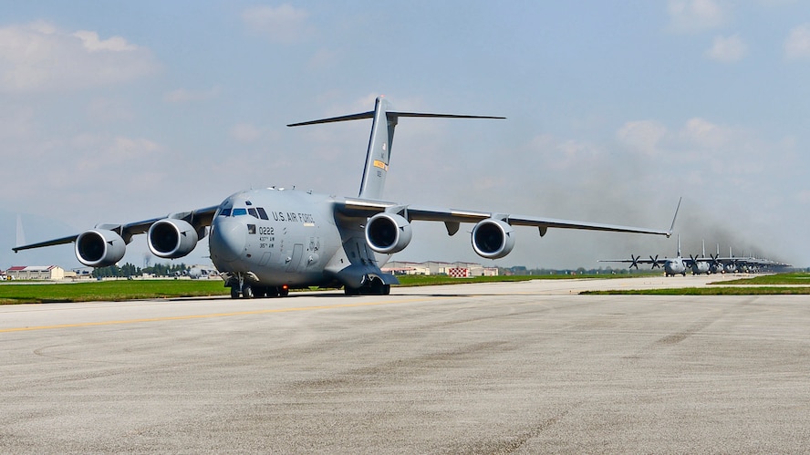 A Charleston C-17 Globemaster III in the lineup ahead of a group of C-130 Hercules aircraft at Aviano Air Base, Italy during large-scale airborne operations at Exercise Saber Junction 16 April 12, 2016. Over 1000 paratroopers and multiple Container Delivery Systems bundles were deployed to provide initial logistical support for follow on missions. Saber Junction 16 will evaluate and assess the readiness of the U.S. Army's 173rd Airborne Brigade to conduct land operations in a joint, combined environment and to promote interoperability with participating Allied and partner nations. Countries participating in the exercise include Albania, Armenia, Bosnia and Herzegovina, Bulgaria, Hungary, Italy, Latvia, Lithuania, Macedonia, Moldova, Romania, Serbia, Slovenia, Sweden, the United Kingdom and the United States. (U.S. Army photo by Visual Information Specialist Gertrud Zach)
