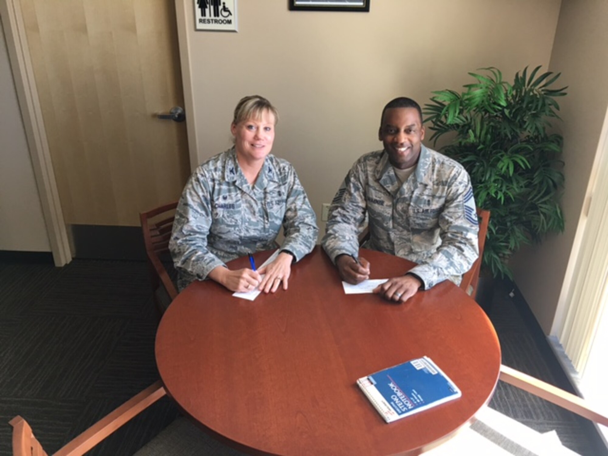 Col. Maureen Charles and Chief Master Sgt. Bruce Mckenzie, 56th Medical Group commander and chief, sign their Air Force Assistance Fund donation forms April 13, 2016, at Luke Air Base, Ariz. The money collected by the campaign will fund four Air Force affiliated charities: the Air Force Villages Foundation, the Air Force Aid Society, the General and Mrs. Curtis E. LeMay Foundation and the Air Force Enlisted Village. (Courtesy Photo)