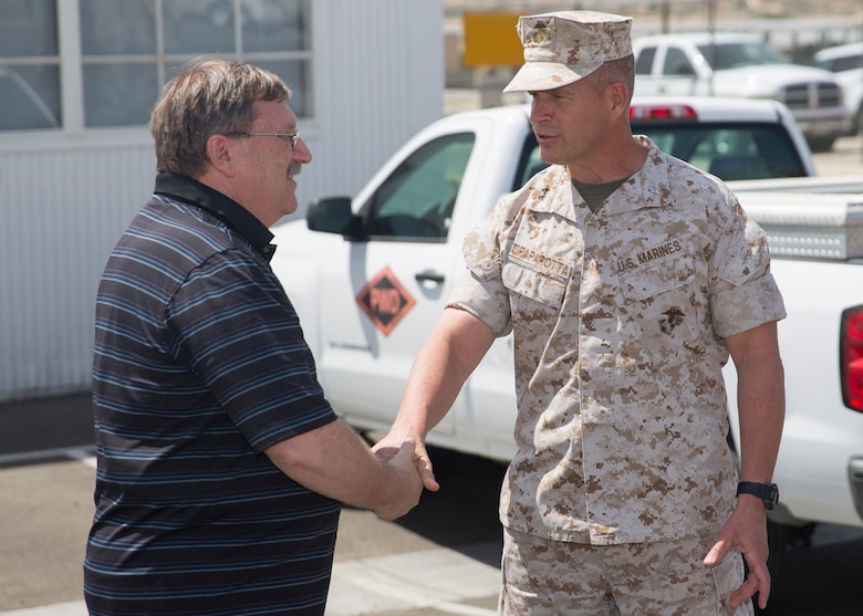 Maj. Gen. Lewis A. Craparotta, Combat Center Commanding General, congratulates Ricky Brennan, contract surveillance representative, Public Works Division, for achieving the Federal Length of Service Award, at the Combat Center’s Public Works Division, April 6, 2016. Brennan was awarded for 40 years of government service. (Official Marine Corps photo by Cpl. Connor Hancock/Released)