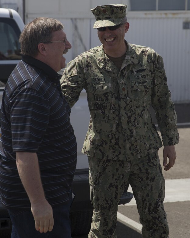 Lt. Cmdr. Ernesto S. Padilla, Facilities Engineering and Acquisition director, Public Works Department, congratulates Ricky Brennan, contract surveillance representative, PWD, following his award ceremony at the Combat Center’s Public Works Division, April 6, 2016. Brennan was awarded the Federal Length of Service Award for 40 years of government service. (Official Marine Corps photo by Cpl. Connor Hancock/Released)