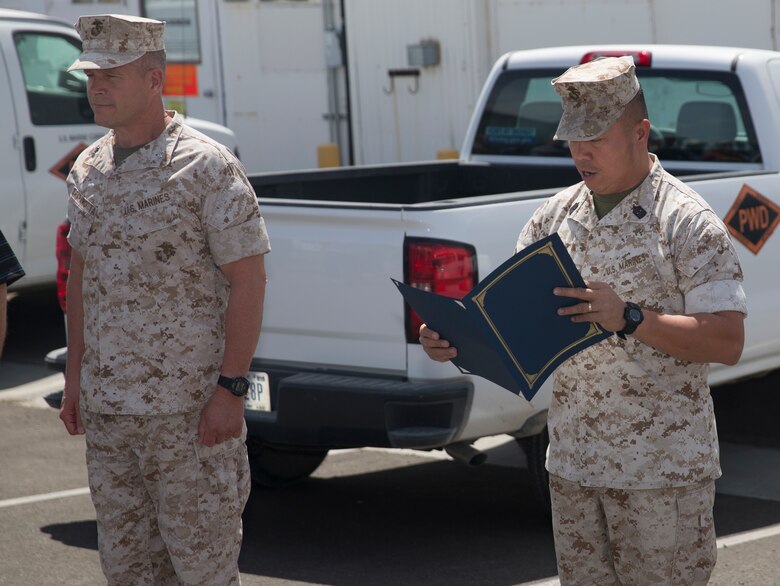 Sgt. Maj. Karl Villalino, Combat Center Sergeant Major, reads the Federal Length of Service award citation for Ricky Brennan, contract surveillance representative, Public Works Division, at the Combat Center’s PWD, April 6, 2016. (Official Marine Corps photo by Cpl. Connor Hancock/Released)