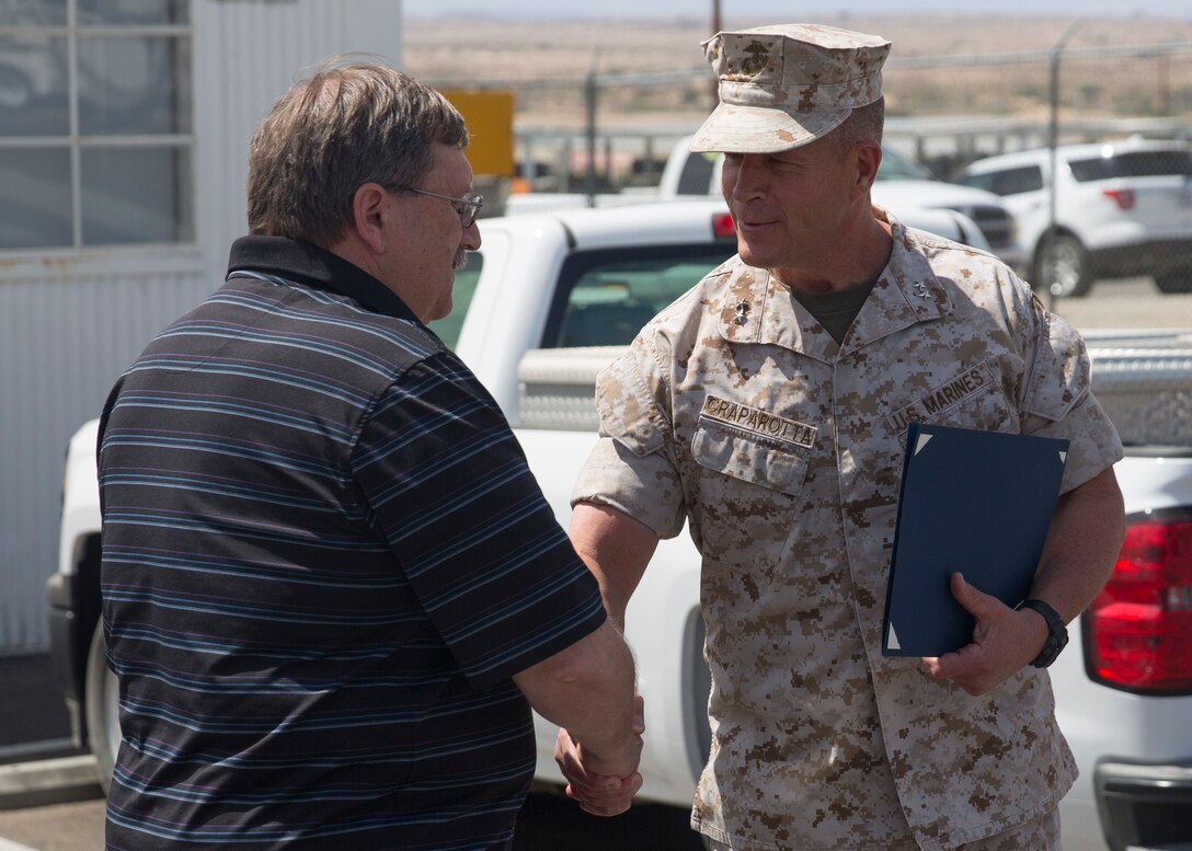 Maj. Gen. Lewis A. Craparotta, Combat Center Commanding General, congratulates Ricky Brennan, contract surveillance representative, Public Works Division, for achieving the Federal Length of Service Award at the Combat Center’s Public Works Division, April 6, 2016. Brennan was awarded for 40 years of government service. (Official Marine Corps photo by Cpl. Connor Hancock/Released)