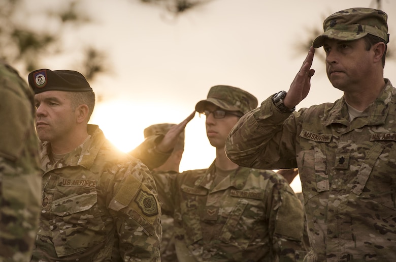 U.S. Air Force Airmen from the 93d Air Ground Operations Wing salute as taps is played, April 15, 2016, at Avon Park Air Force Range, Fla. The Airmen gathered to pay tribute to Lt. Col William Schroeder, who served alongside many members of the 93d AGOW. (U.S. Air Force Photo by Senior Airman Ryan Callaghan/Released)
