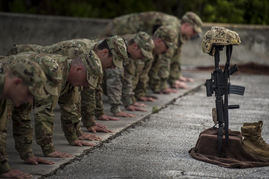 U.S. Air Force Airmen from the 93d Air Ground Operations Wing perform pushups as a tribute to fallen Terminal Air Control Party Airmen, April 15, 2016, at Avon Park Air Force Range, Fla. The Airmen gathered to pay tribute to Lt. Col William Schroeder, who served alongside many members of the 93d AGOW. (U.S. Air Force Photo by Senior Airman Ryan Callaghan/Released)
