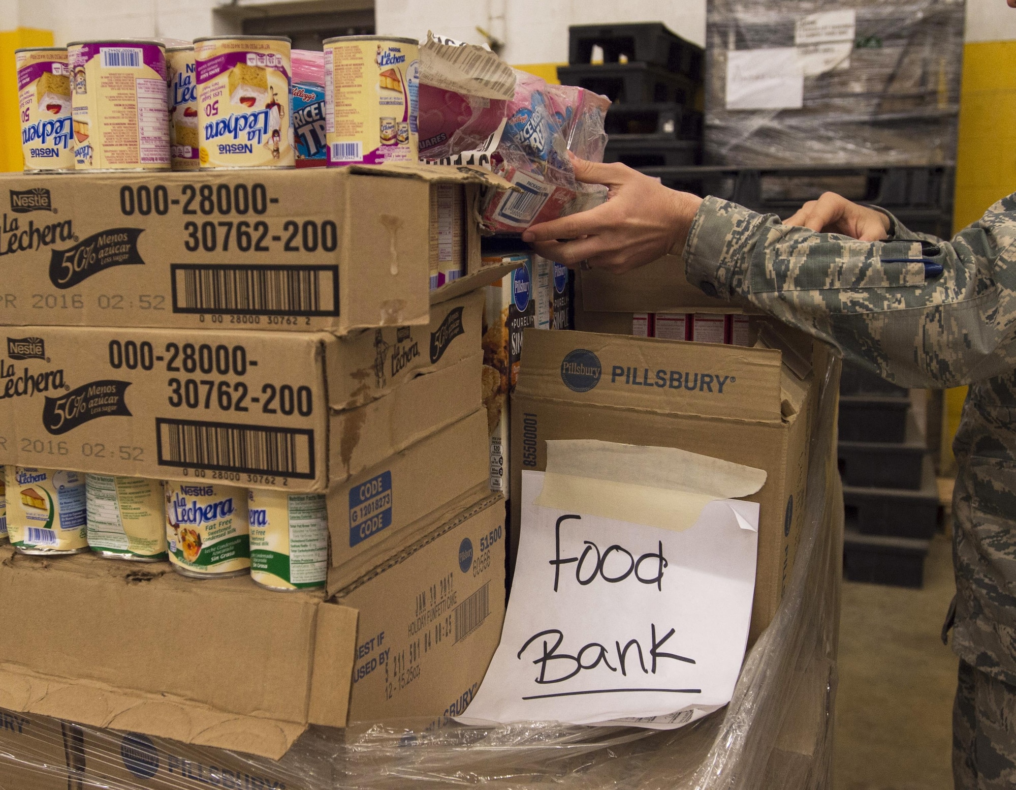 Capt. Carlos Cueto Diaz, Joint Base Andrews’ food bank liaison, adjusts donated goods at the commissary at JBA, Maryland, April 7, 2016. In the last year, JBA has contributed nearly 10,000 pounds of food as part of the Defense Commissary Agency’s established process for covering diversion of unsellable but edible food to local food banks.  (Photo by Senior Airman Nesha Humes/RELEASED)