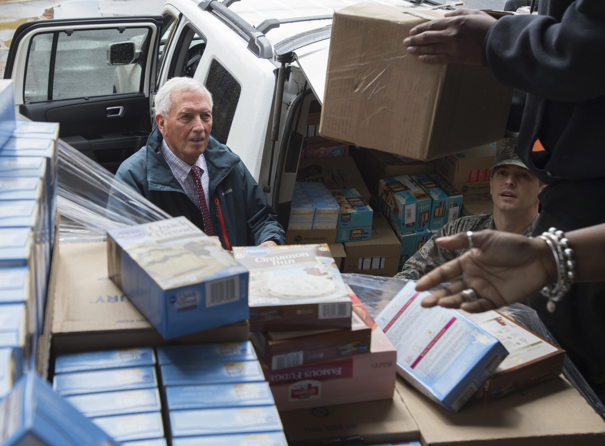 Robert Clagett, Feds Feeds Families volunteer and Capt. Carlos Cueto Diaz, Joint Base Andrews food bank liaisons, load donated goods into vehicle prior to distribution at JBA, Maryland, April 7, 2016. In the last year, JBA has contributed nearly 10,000 pounds of food as part of the Defense Commissary Agency’s established process for covering diversion of unsellable but edible food to local food banks.  (Photo by Senior Airman Nesha Humes/RELEASED)