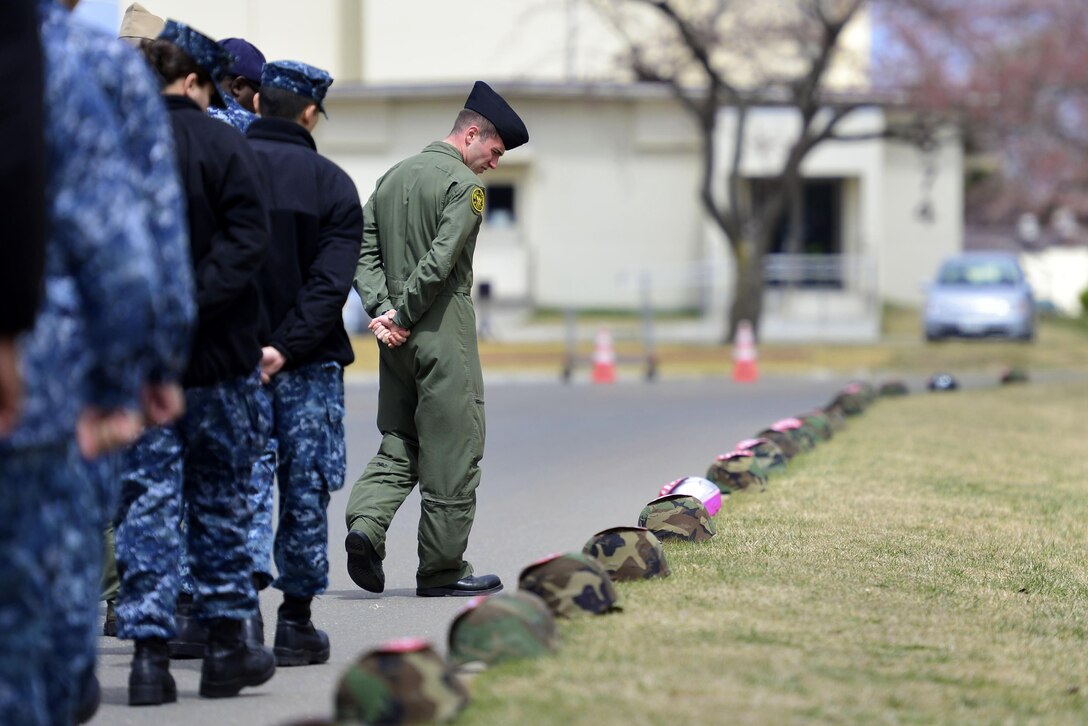Petty Officer 2nd Class Morgan Reeves participates in a silent march at Misawa Air Base, Japan, April 15, 2016, in recognition of Sexual Assault Awareness and Prevention Month. The helmets symbolized cases of violence reported in the past year. Reeves is a naval aircrewman. Navy photo by Petty Officer 3rd Class Samuel Weldin