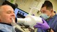 Airman 1st Class Edward Urtiaga, 31st Dental Squadron technician, x-rays retired Col. Dennis Pearman’s teeth during Retiree Appreciation Day at Aviano Air Base, Italy. (U.S. Air Force photo/Senior Airman Matthew Lotz)