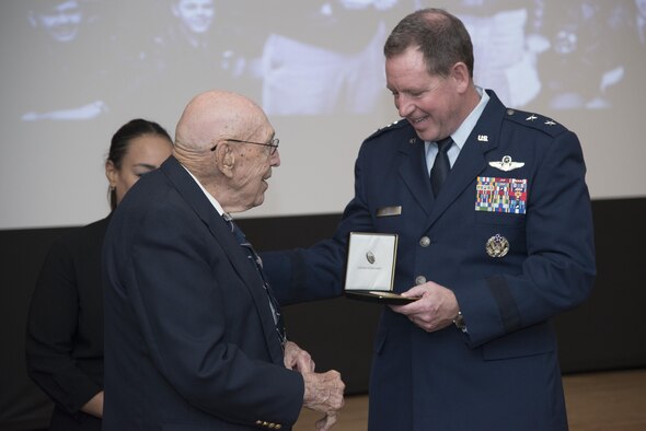 Lt. Col. Dick Cole presents a replica of his Congressional Gold Medal to Maj. Gen. James Hecker, 19th Air Force commander, April 18 at Joint Base San Antonio-Randolph. The Congressional Gold Medal is awarded to persons who have performed an achievement that has an impact on American history and culture that is likely to be recognized as a major achievement in the recipient's field long after the achievement.