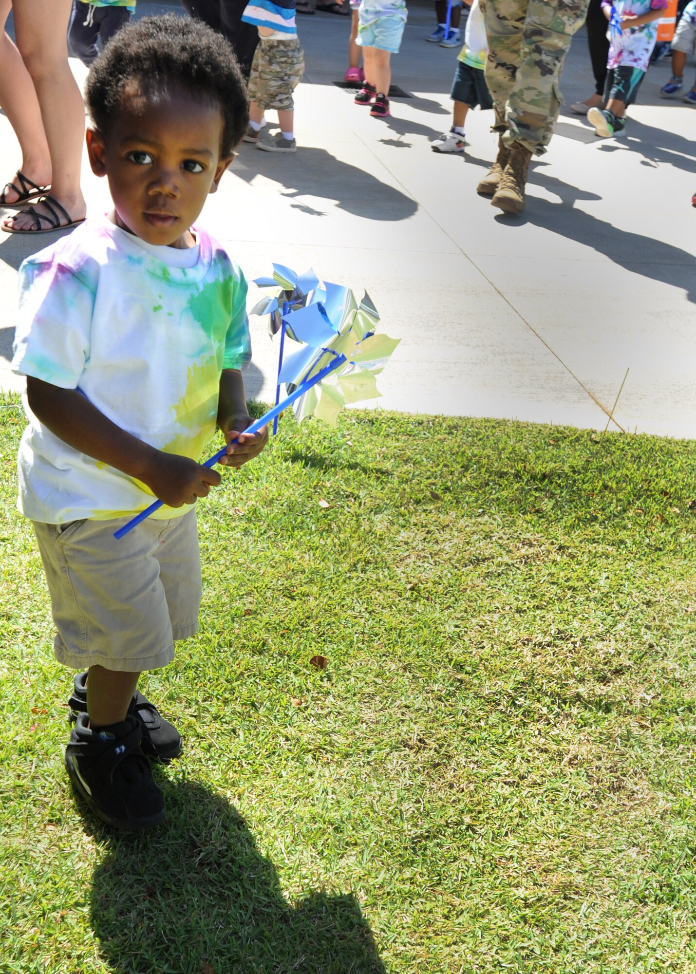 A toddler holds a pinwheel as part of the pinwheel planting ceremony held at the Center Drive Child Development Center on Joint Base Pearl Harbor-Hickam, Hawaii, April 15, 2016. Children, parents and leadership took part in parade and carnival on the playground at the CDC in celebration of the Month of the Military Child and planted pinwheels in honor of Child Abuse Prevention Month. (U.S. Air Force photo by Capt. Nicole White/Released)
