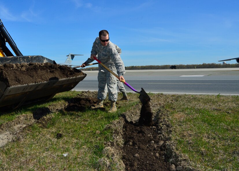 Senior Airman Patrick Dwight, 436th Civil Engineer Squadron heavy equipment and pavements, fills in a rut next to the flight line during a spring cleanup event April 18, 2016, at Dover Air Force Base, Del. Several 436th CES heavy equipment operators, known as “Dirt Boys”, fixed minor issues across the base during the event. (U.S. Air Force photo/Senior Airman William Johnson)