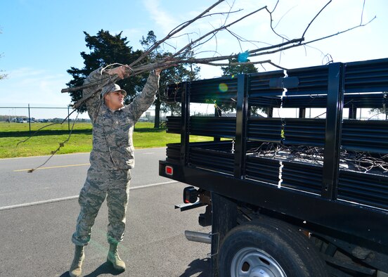 Airman 1st Class Adrian Onzures, 736th Aircraft Maintenance Squadron crew chief, loads tree limbs into the back of a truck during a spring cleanup event April 18, 2016, at Dover Air Force Base, Del. More than 40 Airmen from across the base helped to clean up trash, pick weeds and gather all fallen tree limbs. (U.S. Air Force photo/Senior Airman William Johnson) 