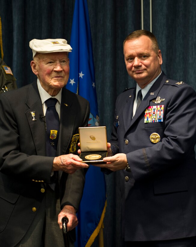 Army Air Force Staff Sgt. David Thatcher presents Col. Brian McDaniel, 92nd Air Refueling Wing commander, with a replica Congressional Gold Medal April 18, 2016, at Fairchild Air Force Base, Wash. The Doolittle Raid was a pivotal point in World War II giving a moral boost to America and proving to the Japanese High Command that their home islands were not invulnerable.