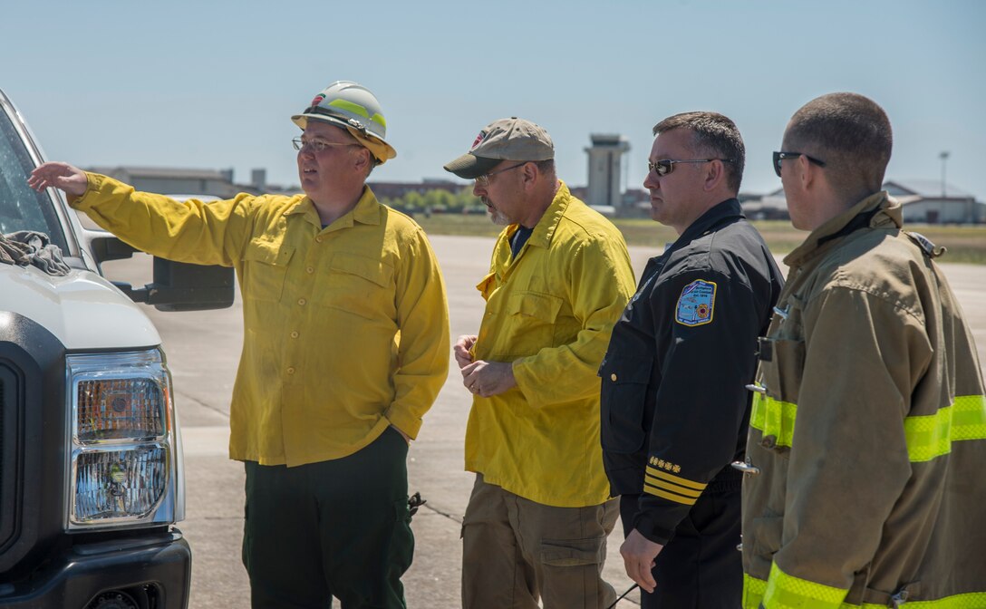 Members of the 633rd Civil Engineer Squadron fire department and the Virginia Department of Forestry discuss plans for a controlled burn at Langley Air Force Base, Va., April 17, 2016. The controlled burn prepared the grassy area on the flight line for the upcoming AirPower over Hampton Roads Open House fireworks display. (U.S. Air Force photo by Senior Airman Kayla Newman)