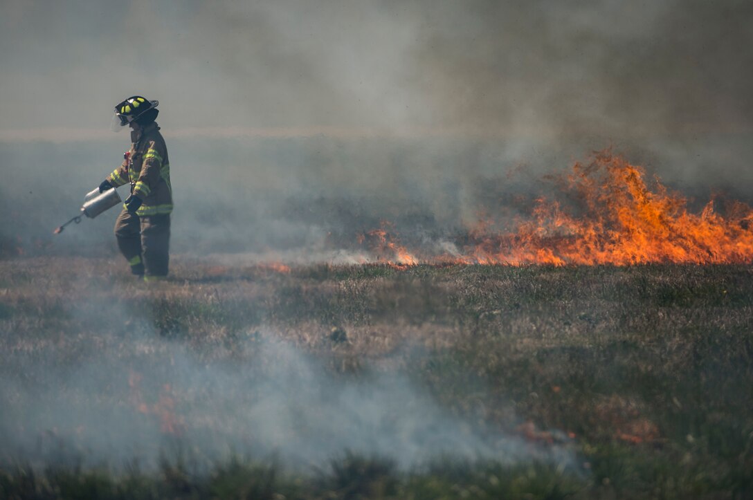 A U.S. Air Force firefighter assigned to the 633rd Civil Engineer Squadron ignites a fired during a controlled burn at Langley Air Force Base, Va., April 17, 2016. The burn prepared for the upcoming AirPower over Hampton Roads Open House fireworks show. (U.S. Air Force photo by Senior Airman Kayla Newman)