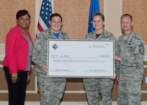 Joint Base Langley-Eustis leadership receive a symbolic check during the Annual Volunteer Salute ceremony at Langley Air Force Base, Va., April 15, 2016. The annual ceremony honors the contributions of JBLE volunteers which saved JBLE nearly $1.2 million in expenses in 2015. (U.S. Air Force photo by Senior Airman R. Alex Durbin/Released)