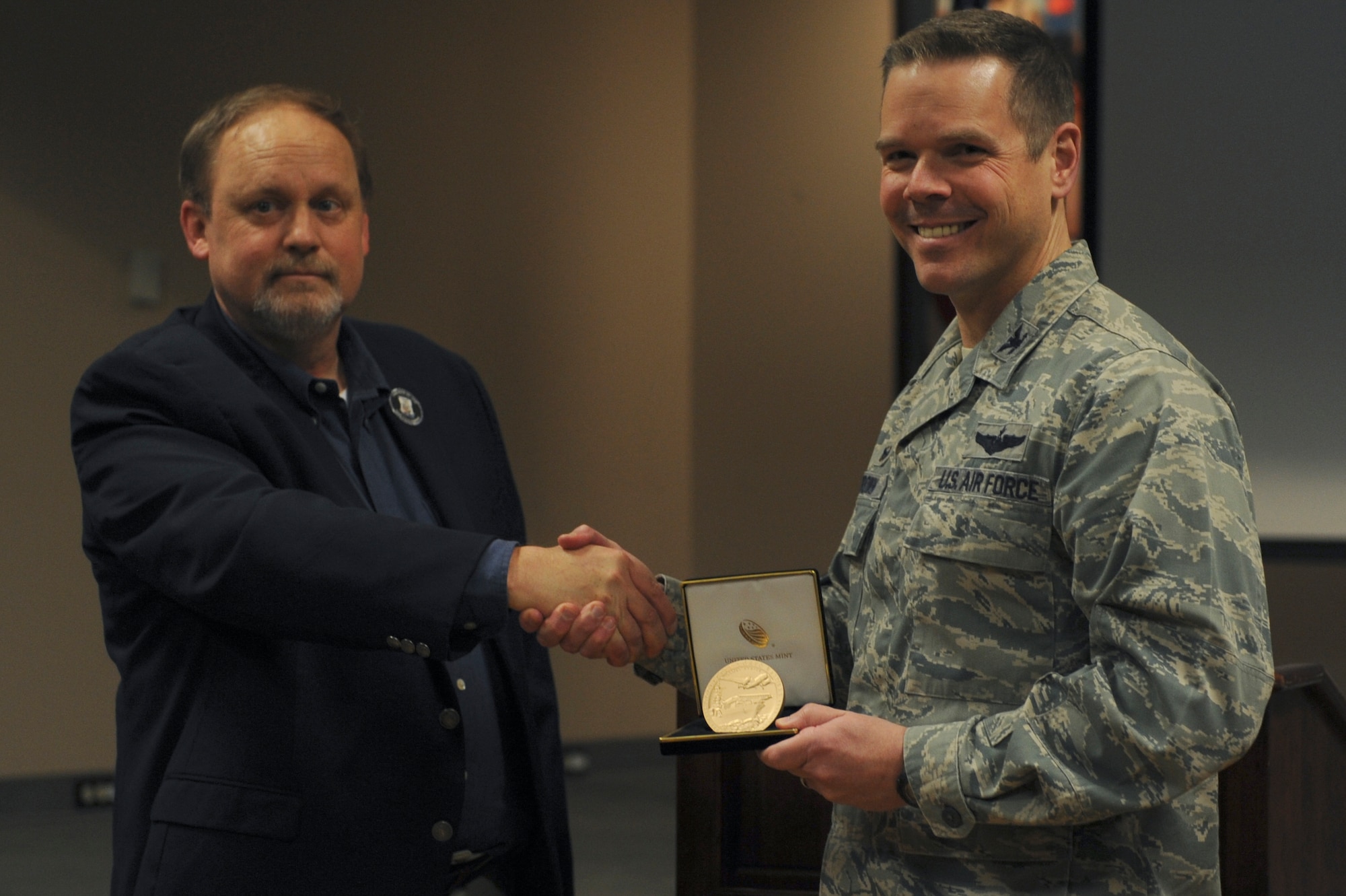 From left, Jeff Thatcher, Children of the Doolittle Raiders president and son of Staff Sgt. David Thatcher, presents U.S. Air Force Col. Charles Brown, 19th Airlift Wing commander, with a commemorative medal April 18, 2016, at Little Rock Air Force Base, Ark. This year, Team Little Rock hosted the 74th anniversary toast with the last two surviving members from the Doolittle Raid. (U.S. Air Force photo by Airman 1st Class Mercedes Taylor)