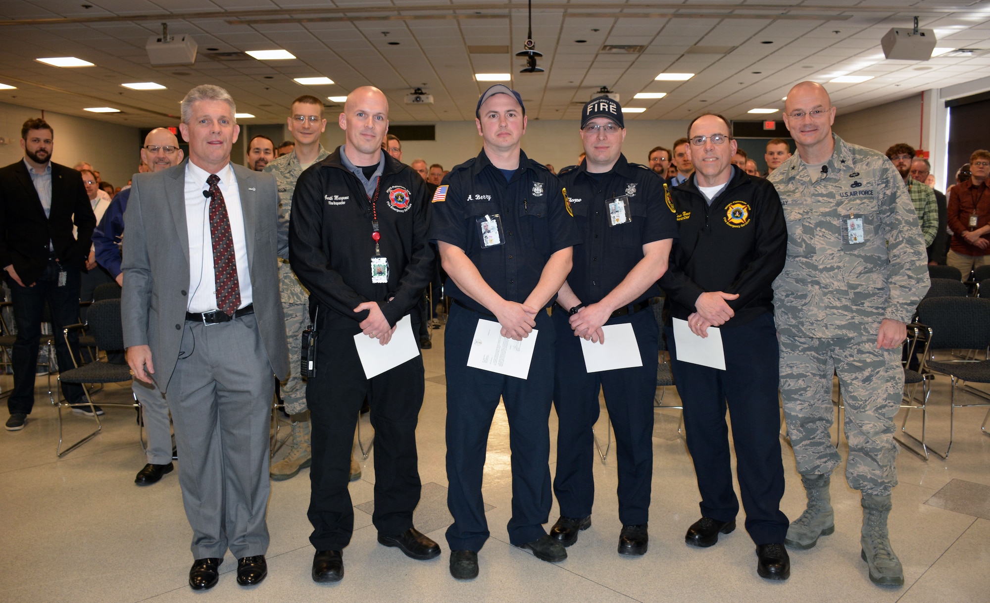 Personnel from the AFRL Materials and Manufacturing Directorate look on as Mr. Thomas Lockhart (left), Director, honors Inspector Garth Musgrove, Engine 32 representative Abram Berry, Engine 31 representative Zacherias Thorpe, and District Chief Kevin Narad of the Wright-Patterson Air Force Base Fire Department on April 12 for their quick response to a flooding event at the directorate.  Brigadier General Allan Day, Commander, Defense Logistics Agency Aviation, was also present at the event to offer his thanks.  (U.S. Air Force Photo/David Dixon)
