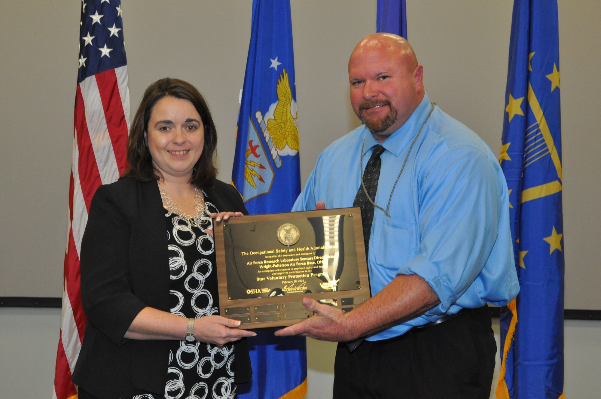 Kenneth Montgomery, Occupational Safety and Health Administration Area Director of the Cincinnati Area Office, presents an OSHA VPP Star status plaque to Ruth Moser, director of AFRL's Sensors Directorate. The Sensors Directorate is one of only 56 certified VPP Star sites in the Department of Defense and one of less than 2,300 OSHA certified VPP Star sites in the country. (U.S. Air Force photo/Bryan Ripple)