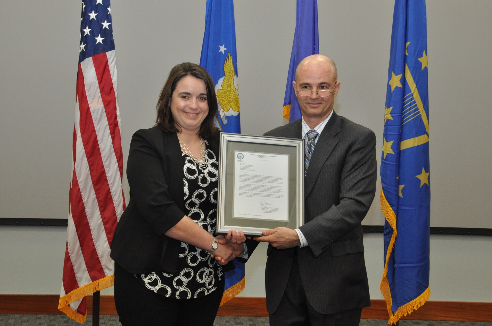 Leonard Litton III, Department of Defense Director of Personnel Risk Reduction presented a congratulatory letter from Brad Carson, performing the duties of the Principal Deputy Under Secretary of Defense for Personnel and Readiness to Ruth Moser, director of the Sensors Directorate during the directorate's OSHA Voluntary Protection Program Star Site award recognition ceremony April 13. The letter stated that the directorate is one of only 56 certified VPP Star sites in the Department of Defense and one of less than 2,300 OSHA certified VPP Star sites in the country. (U.S. Air Force photo/Bryan Ripple)