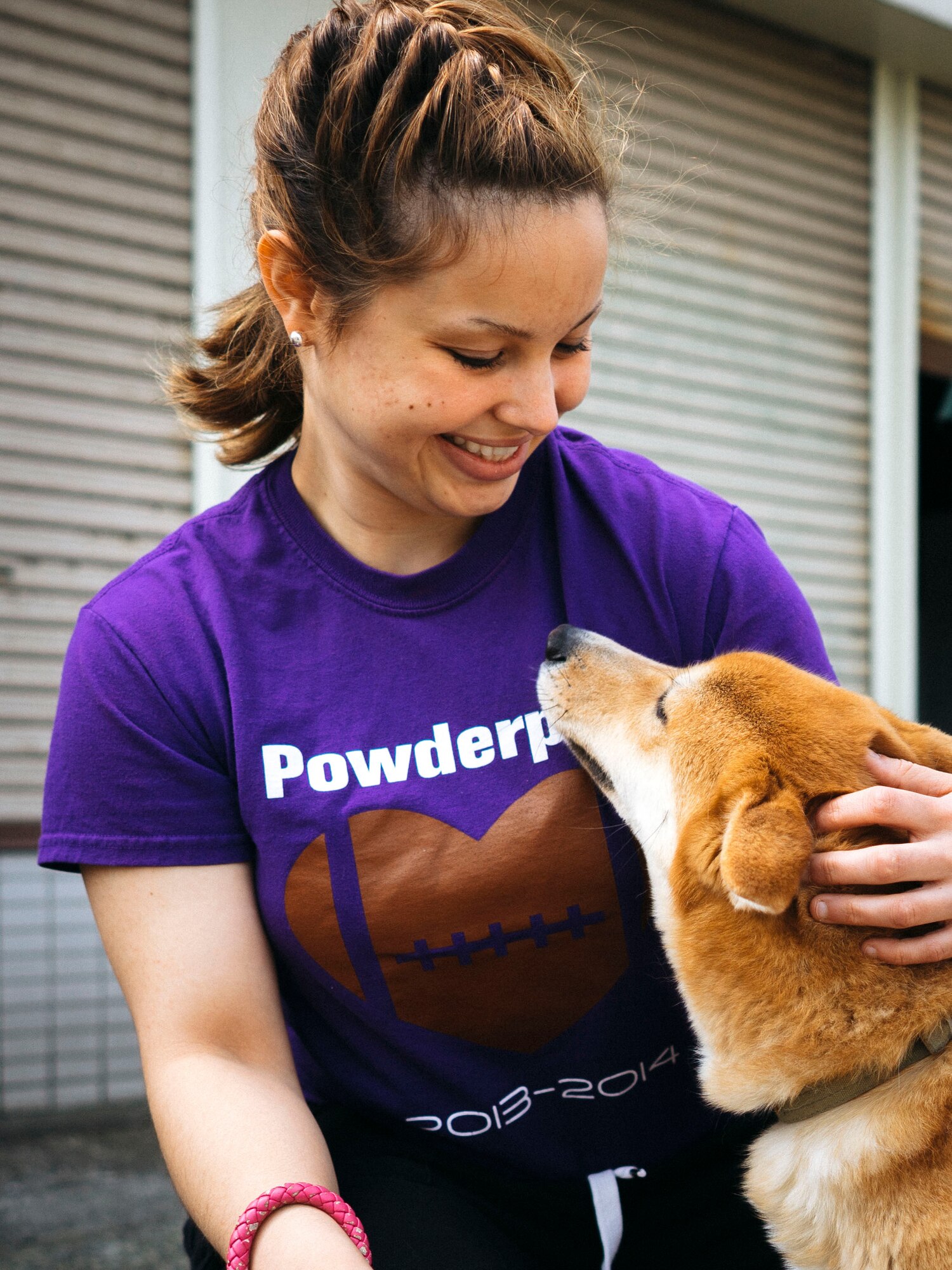 Airman Natalie Gaston, 374th Medical Support Squadron bioenvironmental technician, pets a dog while volunteering at an animal shelter in Akishima, Japan, April 16, 2016. Over the course of two days, 20 Airmen volunteered their time in the local community by assisting an animal shelter with cleaning projects, walking dogs and grooming. (U.S. Air Force photo by Senior Airman Delano Scott/Released)
