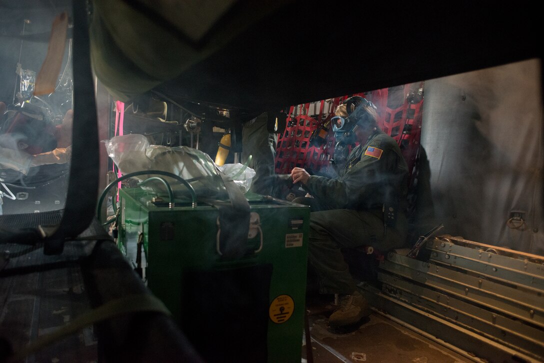 An aeromedical evacuation flight commander dons an oxygen mask during a simulated fire aboard a C-130 Hercules aeromed specific trainer as part of the Multiple Aircraft Training Opportunity Program training event held at Will Rogers Air National Guard Base, Oklahoma City, April 15-16, 2016. The 137th Aeromedical Evacuation Squadron hosted five other aeromedical squadrons at the two day event. (U.S. Air National Guard photo by Master Sgt. Andrew LaMoreaux/Released) 
