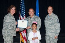 Isabella Torres poses with her father, 2nd Lt. Angel Torres, Air Force Life Cycle Management Information Technology Business Analytic Office program manager, as he receives his Presidential Volunteer Service Award, during the Volunteer Recognition Awards ceremony, April 15, 2016, Maxwell Air Force Base, Ala. Along with her father, Isabella also earned the same award, making her Maxwell’s youngest volunteer to be recognized. (U.S. Air Force photo by Airman 1st Class Alexa Culbert)