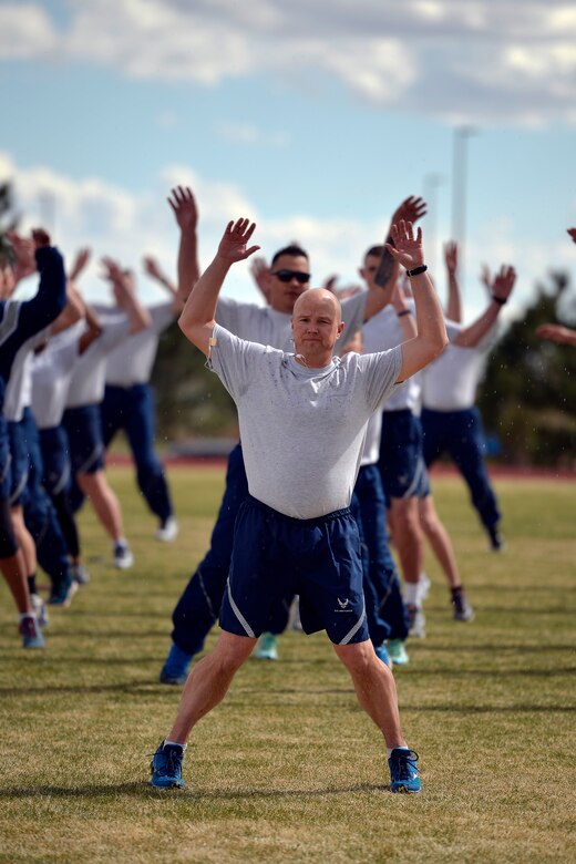 Airmen with the 50th Space Wing warm up prior to the Warfit Run at Schriever Air Force Base, Colorado, Wednesday, April 13, 2016. The monthly run is open to military, civilian and dependents.  (U.S Air Force photo/Dennis Rogers)