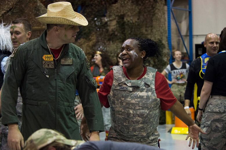 Maj. Rodney Lambert, 50th Contracting Squadron commander, and Maj. Latoya Smith, 50th Comptroller Squadron, engage in smack talk during the 2016 Combat Dining Out at Schriever Air Force Base, Colorado, Friday, April 15, 2016. More than 140 50 MSG, Wing Staff Agency, Colorado Springs Regional Command Post, civic and family members attended the event. (U.S. Air Force photo/Tech. Sgt. Julius Delos Reyes)